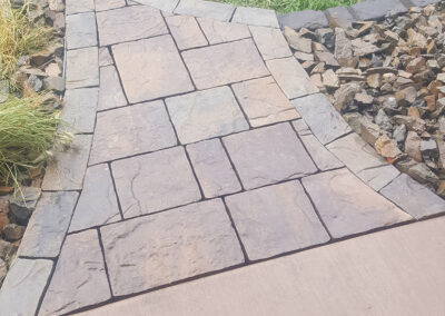 angled stone pathway leading to grass lawn